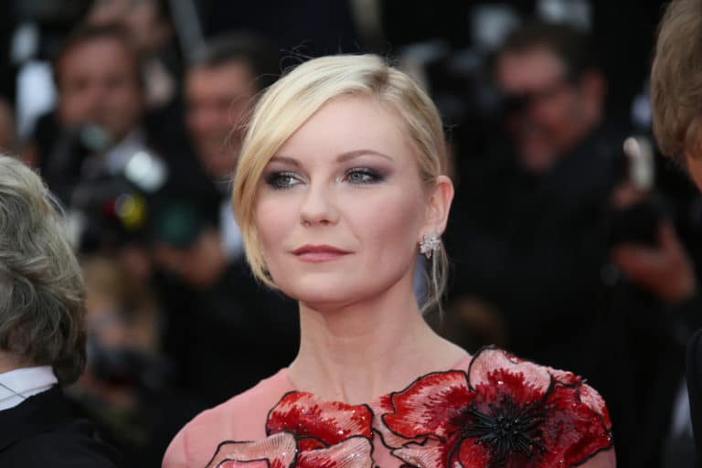 Kirsten Dunst, actriz estadounidense conocida por sus papeles en películas como "Spider-Man" y "Melancholia", posando con una expresión elegante y sofisticada en un evento de alfombra roja. Su estilo distintivo y carisma la han convertido en un ícono de la moda en Hollywood.