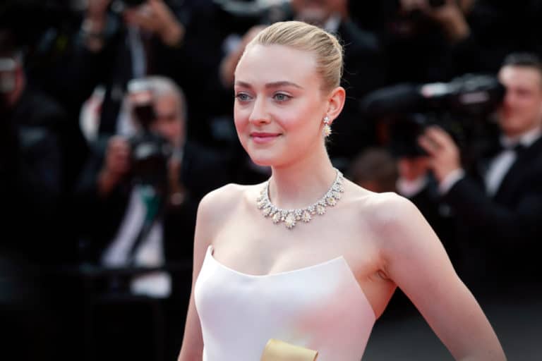 Dakota Fanning, actriz estadounidense conocida por su talento desde una edad temprana, posando con una expresión encantadora en un evento de alfombra roja. Su estilo elegante y su presencia carismática la han convertido en una figura destacada en la industria del cine.